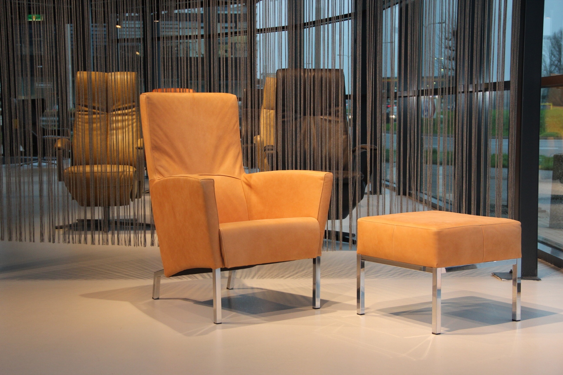 Design fauteuil Living in leer van Ojee Design met Hocker
